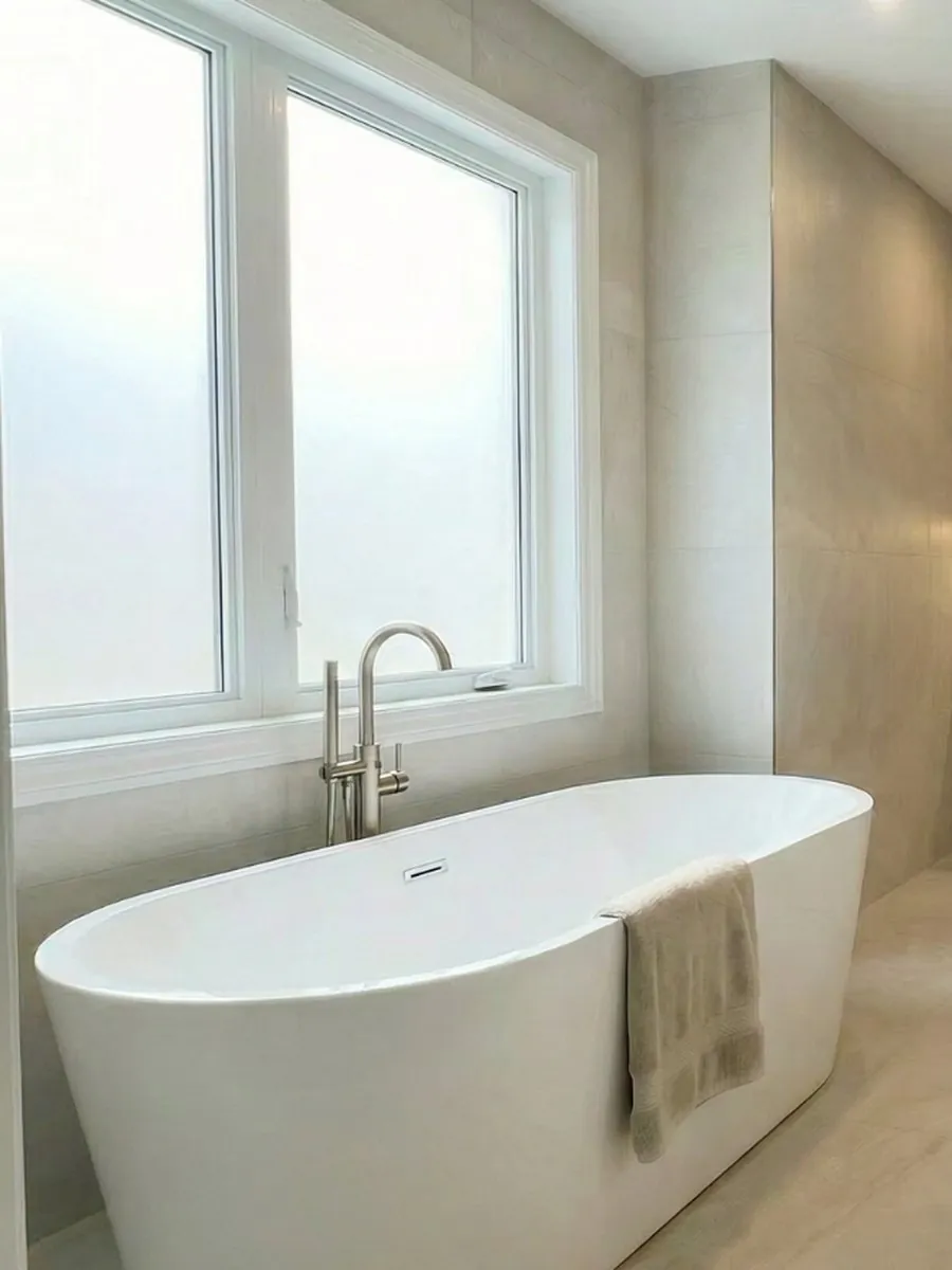 Freestanding tub in a bright ensuite with large-format tile